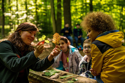 Waldpädagogik mit Kindern Das Bild zeigt: eine Waldpädagogin bei der Arbeit mit Kindern im Wald