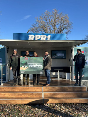 Das Bild zeigt Personen in einem RPR1.-Truck mit einem Schild zur Baumpflanzaktion