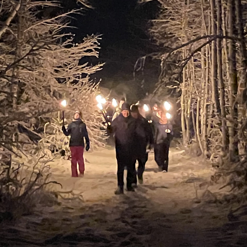Fackelwanderung Das Bild zeigt: eine Gruppe bei einer Fackelwanderung im Winterwald