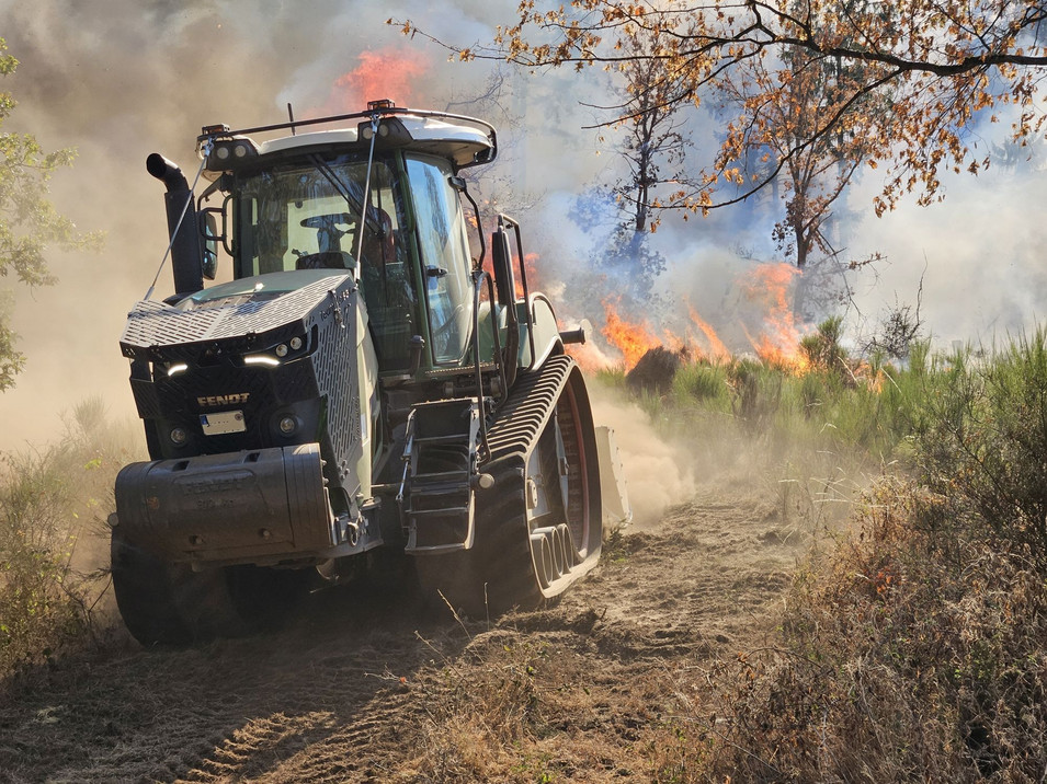 Auf dem Bild sehen Sie eine Forstmaschine im Einsatz bei einem Waldbrand