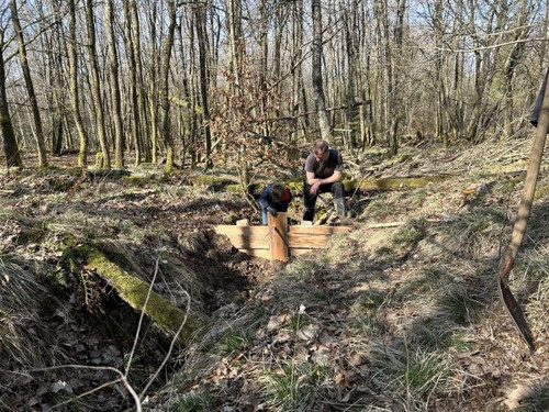 Das Bild zeigt: Vater und Sohn bei der gemeinsam gebauten Staustufe im Entwässerungsgraben.
