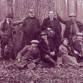 Historisches Bild mit Männern vor einer dicken Eiche