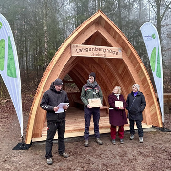 Das Foto zeigt vier Personen vor der Schutzhütte.
