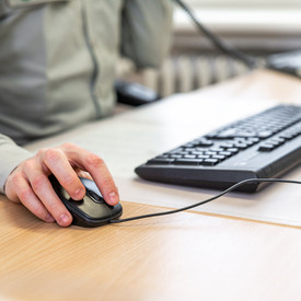 Büroarbeit Das Bild zeigt die Hände einer Person beim Arbeiten am Computer.