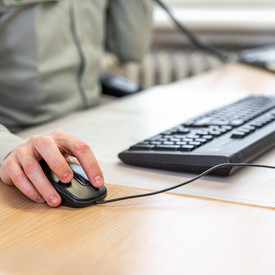Das Bild zeigt die Hände einer Person beim Arbeiten am Computer.