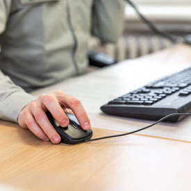 Das Bild zeigt die Hände einer Person beim Arbeiten am Computer.