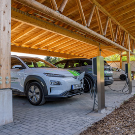 Das Bild zeigt ein E-Dienstfahrzeug beim Laden im Solarcarport.