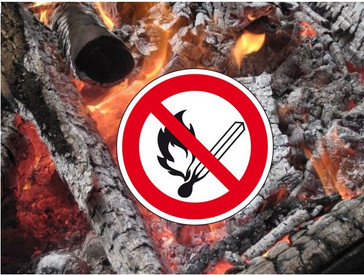Holzfeuer mit Hinweisschild "Rauchen, offenes Licht und Feuer verboten" untersagt. Hinweisschild zeigt roten Kreis mit rotem, diagonalem Querbalken über einem abgebildeten brennenden Streichholz.