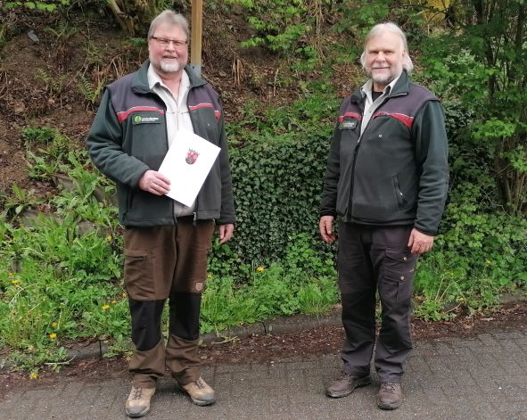 Rolf Lück (links) erhält von Forstdirektor Windand Schmitz die Beförderungsurkunde überreicht.