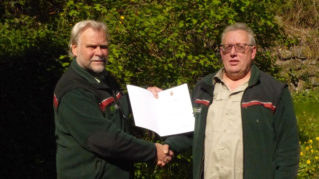Forstamtsleiter Winand Schmitz (links) überreicht dem Mitarbeiter Peter Utsch die Dankesurkunde der Ministerpräsidentin Malu Dreyer